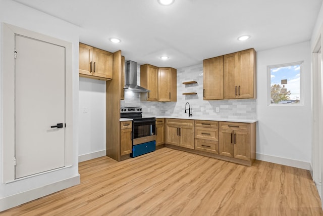 kitchen with sink, light wood-type flooring, range with electric stovetop, decorative backsplash, and wall chimney range hood