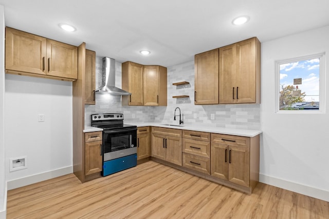 kitchen featuring range with electric cooktop, light wood-type flooring, sink, and wall chimney range hood