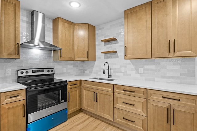 kitchen with wall chimney range hood, sink, light hardwood / wood-style floors, decorative backsplash, and stainless steel range with electric cooktop