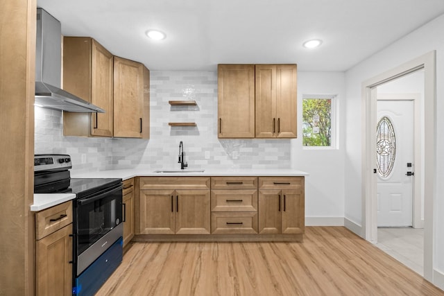 kitchen with sink, tasteful backsplash, light hardwood / wood-style flooring, electric range, and wall chimney range hood