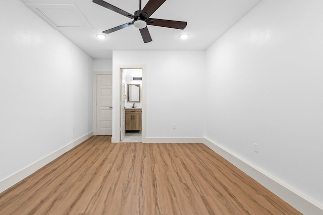 unfurnished bedroom featuring connected bathroom, sink, light hardwood / wood-style floors, and ceiling fan