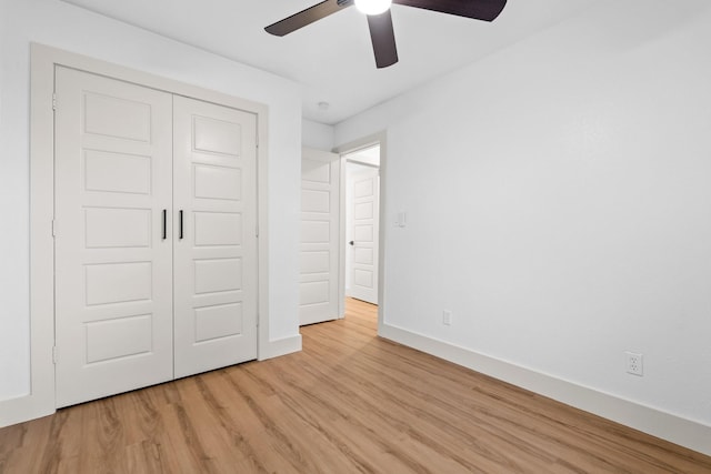 unfurnished bedroom featuring ceiling fan, light hardwood / wood-style floors, and a closet