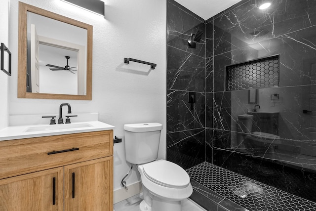 bathroom featuring vanity, tiled shower, and toilet