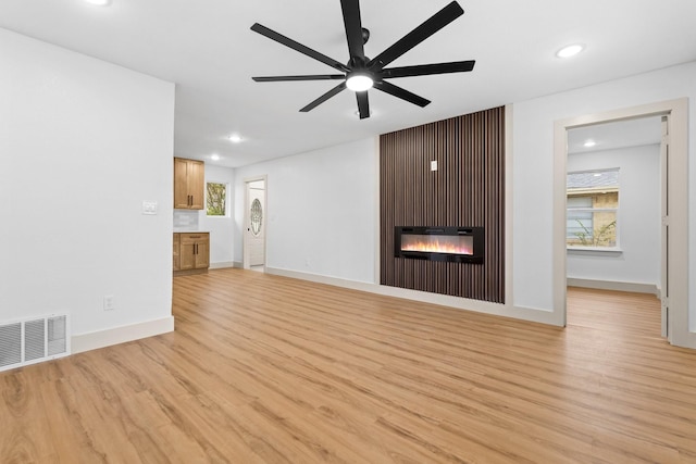 unfurnished living room with ceiling fan and light wood-type flooring