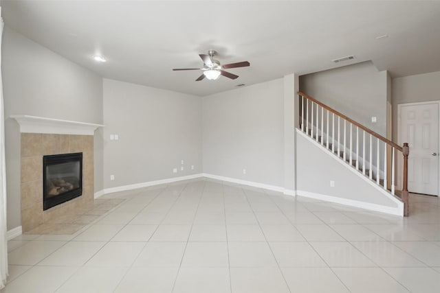 unfurnished living room featuring a fireplace, light tile patterned floors, and ceiling fan