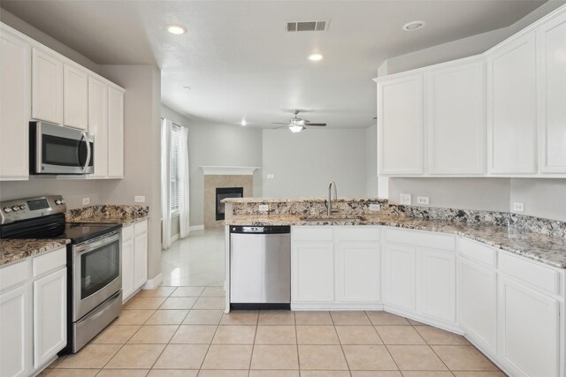 kitchen with white cabinets, sink, ceiling fan, light tile patterned floors, and appliances with stainless steel finishes