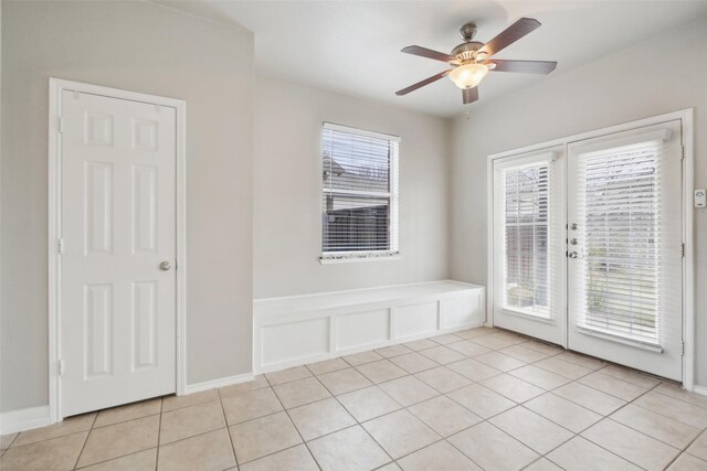 tiled empty room with ceiling fan and french doors