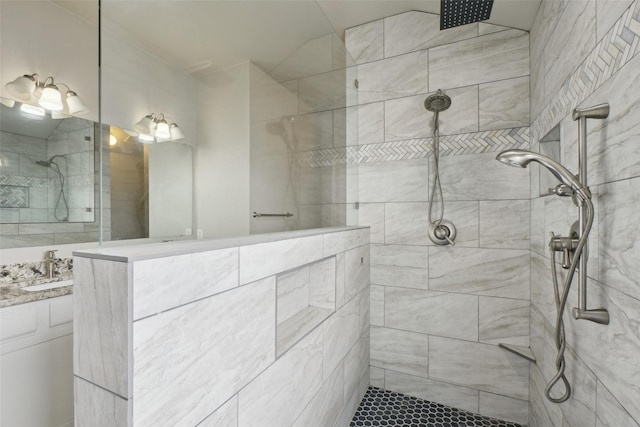 bathroom featuring tiled shower and vanity