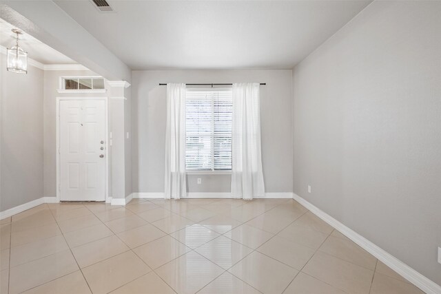 tiled spare room with ornamental molding