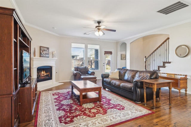 living room with crown molding, hardwood / wood-style floors, and ceiling fan