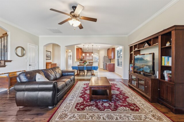 living room with hardwood / wood-style floors, crown molding, and ceiling fan