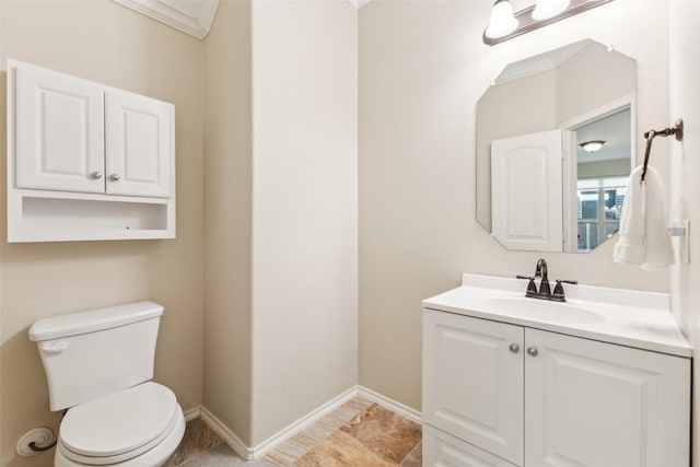 bathroom with vanity, crown molding, and toilet