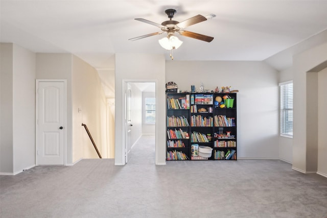 carpeted spare room featuring ceiling fan and vaulted ceiling