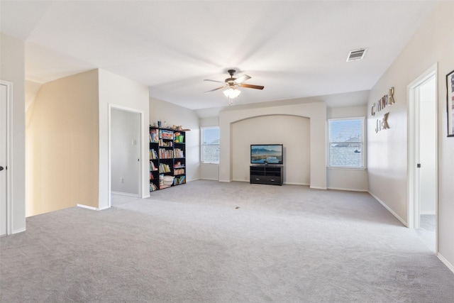 unfurnished living room featuring light colored carpet and ceiling fan