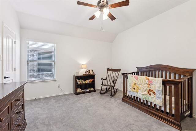 carpeted bedroom with a nursery area, ceiling fan, and vaulted ceiling