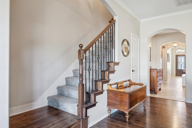 stairs with hardwood / wood-style flooring and ornamental molding