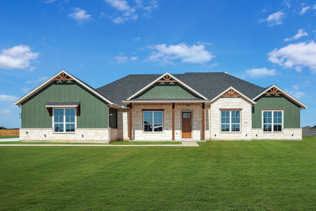 531 N Armstrong Rd, Venus, TX 76084 - view of front of home featuring a shingled roof, a front lawn, board and batten siding, and stone siding