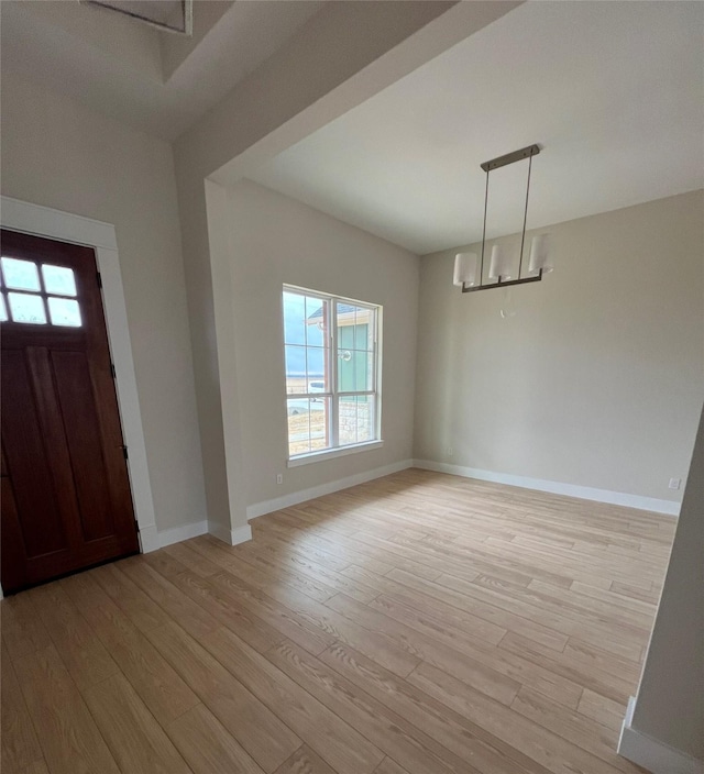 foyer with a chandelier and light wood-type flooring