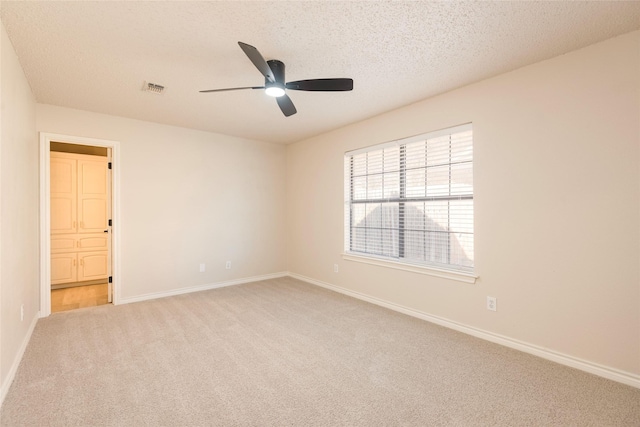 carpeted empty room with a textured ceiling and ceiling fan