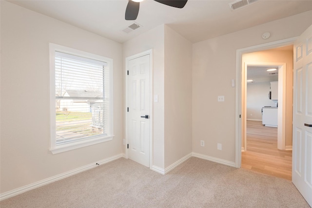 unfurnished bedroom featuring ceiling fan and light carpet