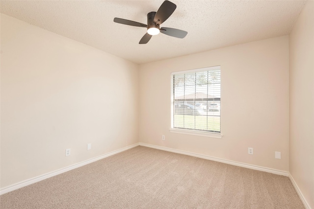 spare room featuring ceiling fan, carpet, and a textured ceiling