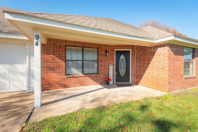 doorway to property with a porch and a garage