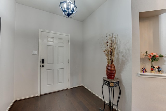 foyer entrance with dark hardwood / wood-style floors and a chandelier