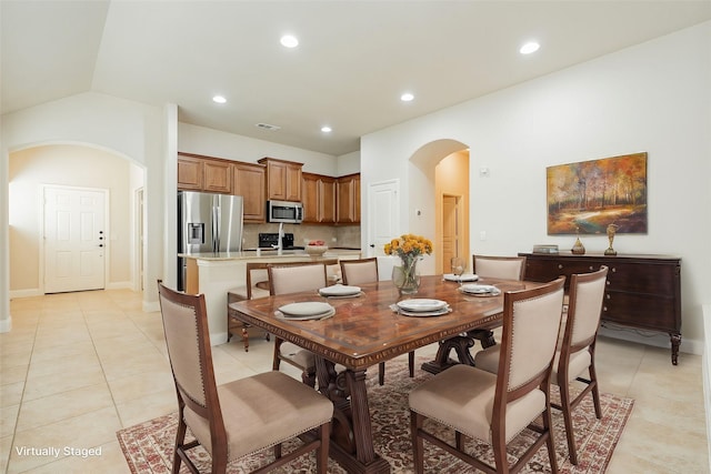 tiled dining room with lofted ceiling