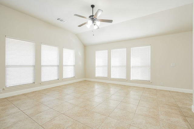 spare room with ceiling fan, lofted ceiling, and light tile patterned floors