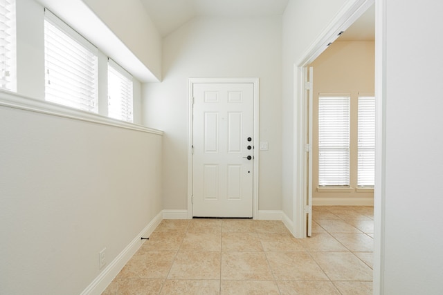 entrance foyer with light tile patterned floors and lofted ceiling