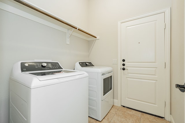 washroom with light tile patterned flooring and washing machine and clothes dryer