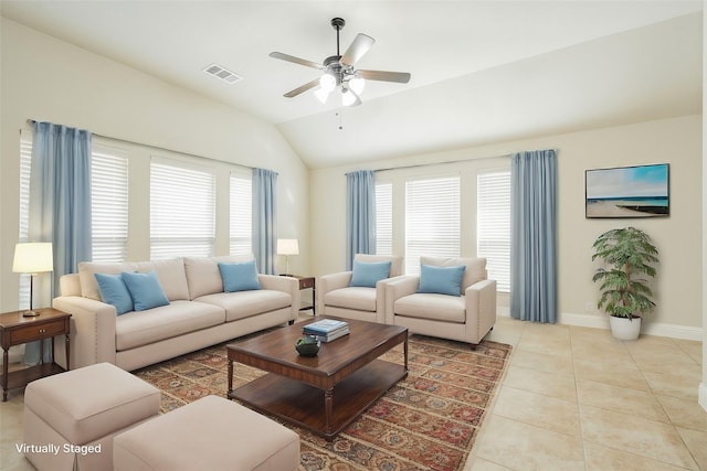 tiled living room with ceiling fan, plenty of natural light, and lofted ceiling