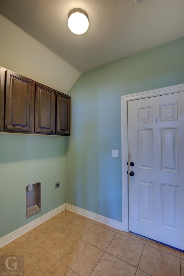 laundry area with electric dryer hookup, light tile patterned flooring, and cabinets