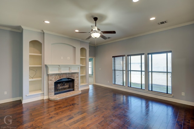 unfurnished living room with crown molding, a brick fireplace, dark wood-type flooring, and built in features