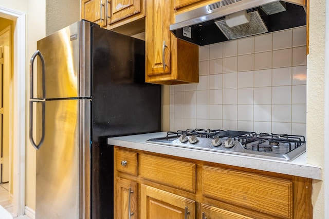 kitchen with stainless steel appliances, backsplash, and range hood