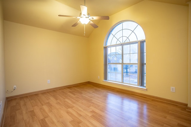 empty room with ceiling fan, lofted ceiling, plenty of natural light, and light hardwood / wood-style flooring