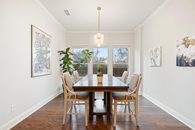 dining space featuring dark wood-type flooring, ornamental molding, and a chandelier