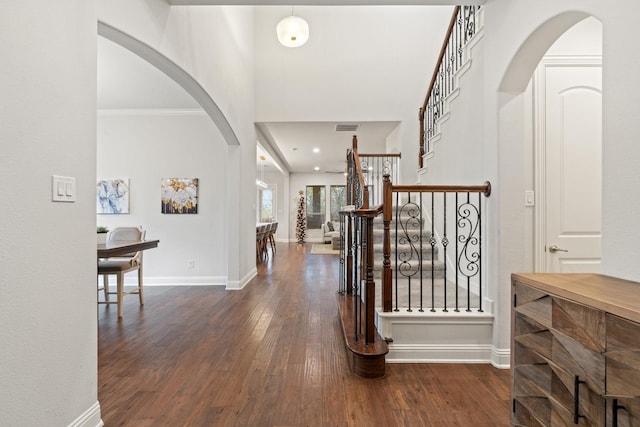 entryway featuring crown molding and dark wood-type flooring