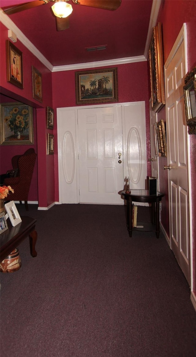 carpeted entrance foyer featuring ornamental molding