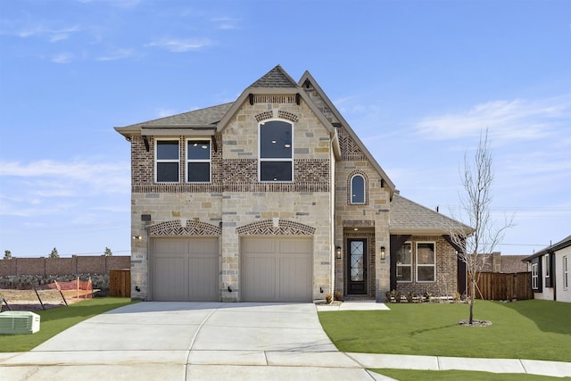 6104 Mulberry Ln, Celina, TX 75009 - french country style house with driveway, a front yard, stone siding, fence, and a shingled roof