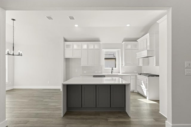 kitchen featuring a notable chandelier, a center island, pendant lighting, and white cabinets