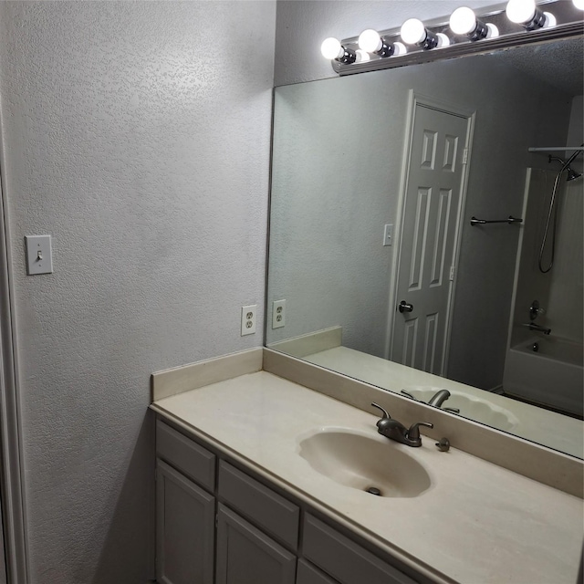 bathroom featuring vanity and  shower combination