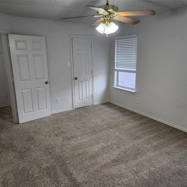 unfurnished bedroom with ceiling fan, carpet flooring, and a textured ceiling