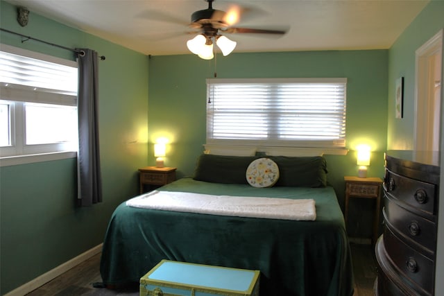 bedroom featuring multiple windows, hardwood / wood-style flooring, and ceiling fan