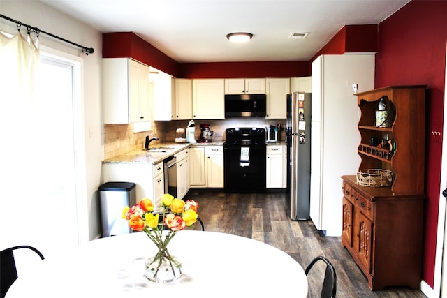 kitchen with appliances with stainless steel finishes, sink, backsplash, dark hardwood / wood-style flooring, and light stone counters