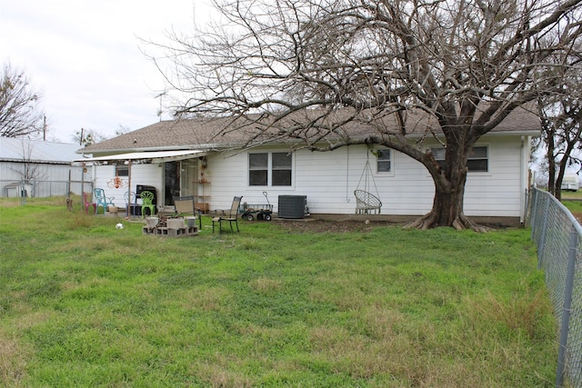 rear view of house featuring cooling unit and a yard