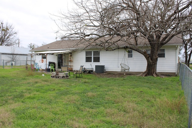 back of property featuring a yard and central AC