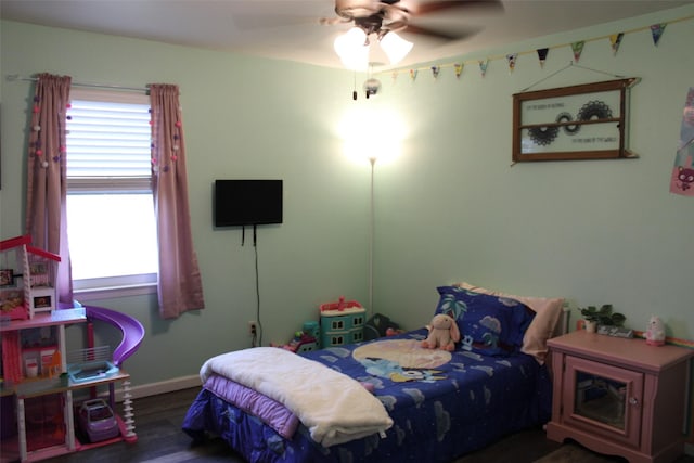 bedroom featuring multiple windows, dark wood-type flooring, and ceiling fan