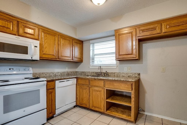 kitchen with white appliances, sink, a textured ceiling, light tile patterned flooring, and light stone counters