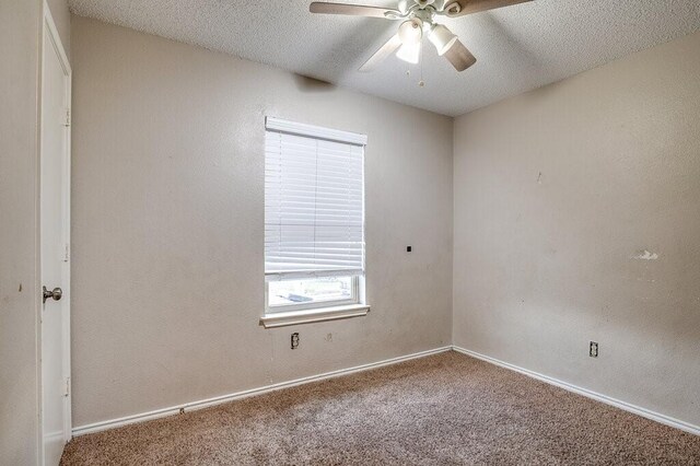 carpeted empty room featuring ceiling fan and a textured ceiling